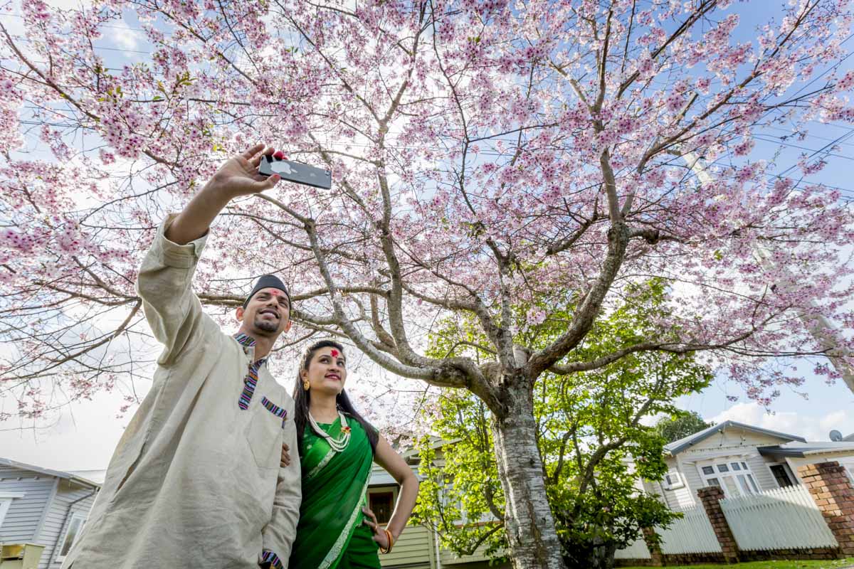 Sanjay and Sugam are Nepalese and celebrate Dashain festival with a selfie in the blossoms of Linwood Ave. Picture: Azita Agnew